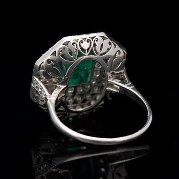 A RING, facetted emerald, brilliant cut diamonds, platinum. Art Deco, ca 1920s.