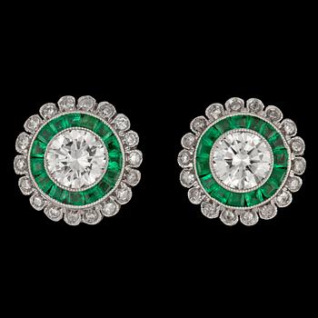 1125. A pair of brilliant cut diamonds, tot. app. 1 cts, and emerald earrings.