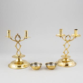 A pair of brass candelabra for two candles "Blekingestakar and a pair of brass cups, 1800/1900.