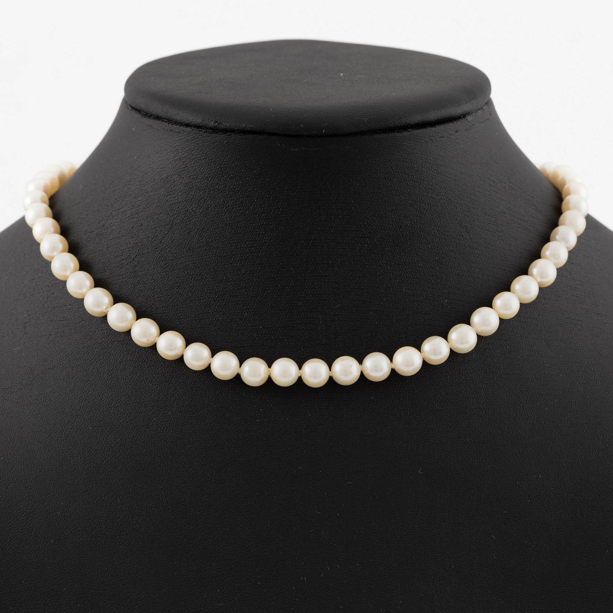 Necklace of cultured pearls with clasp in 18K gold set with white and red stones.