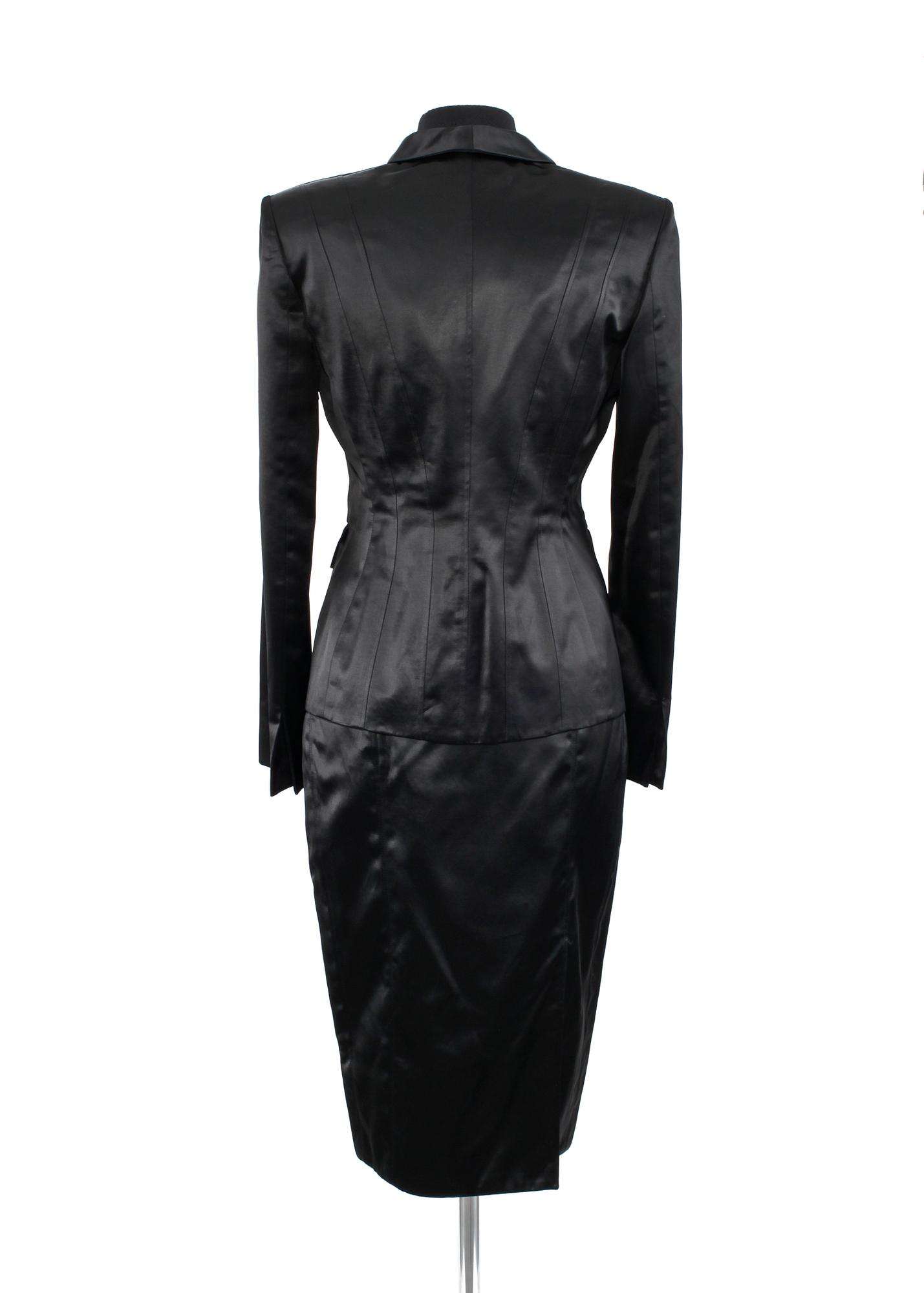 A two-piece black silk costume consisting of jacket and skirt by Gucci.