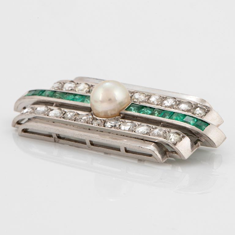 A platinum brooch set with old- and rose-cut diamonds, faceted emeralds and a pearl.