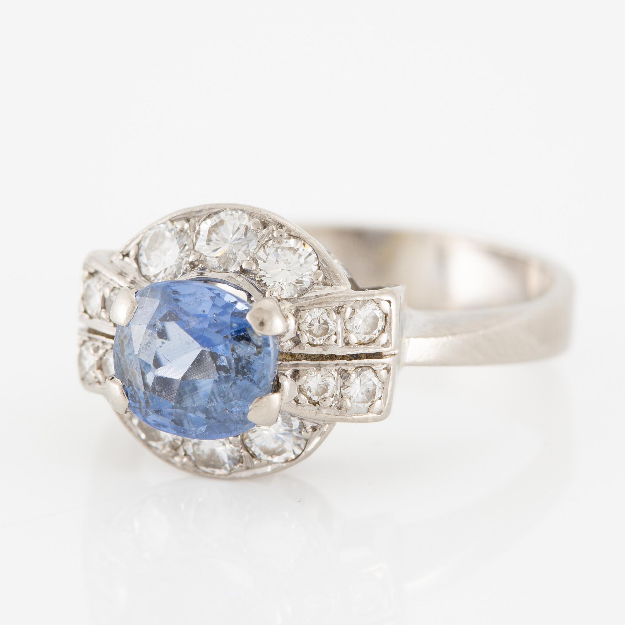 Ring 18K white gold set with a faceted sapphire and round brilliant-cut diamonds.