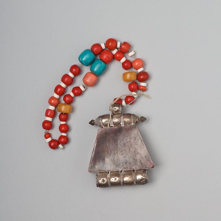 A silvered copper alloy pendant with beads, Tibet, late 19th Century.