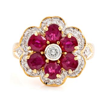 579. An 18K gold, ruby and round brilliant cut diamond flower ring.