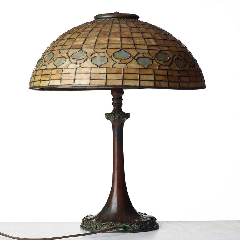 TIFFANY STUDIOS, an Art Nouveau "Vine Border" shade on a "Double Scroll" bronze base table lamp, New York 1902-1918.