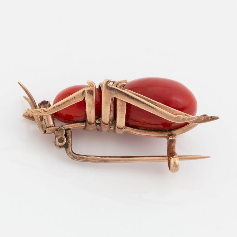 A coral brooch set with pearls and pink sapphires.