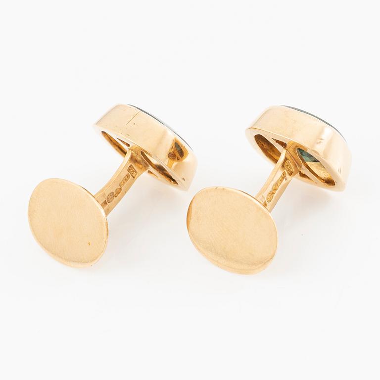 Ett par manschettknappar 18K guld med gröna stenar.