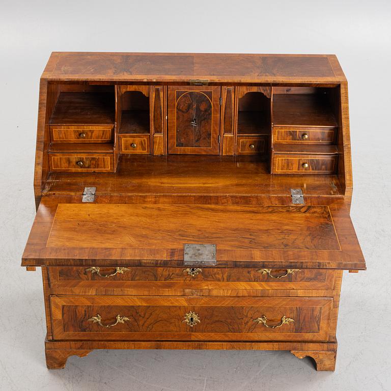 A rococo walnut-veneered and gilt-brass mounted secretaire, later part of the 18th century.