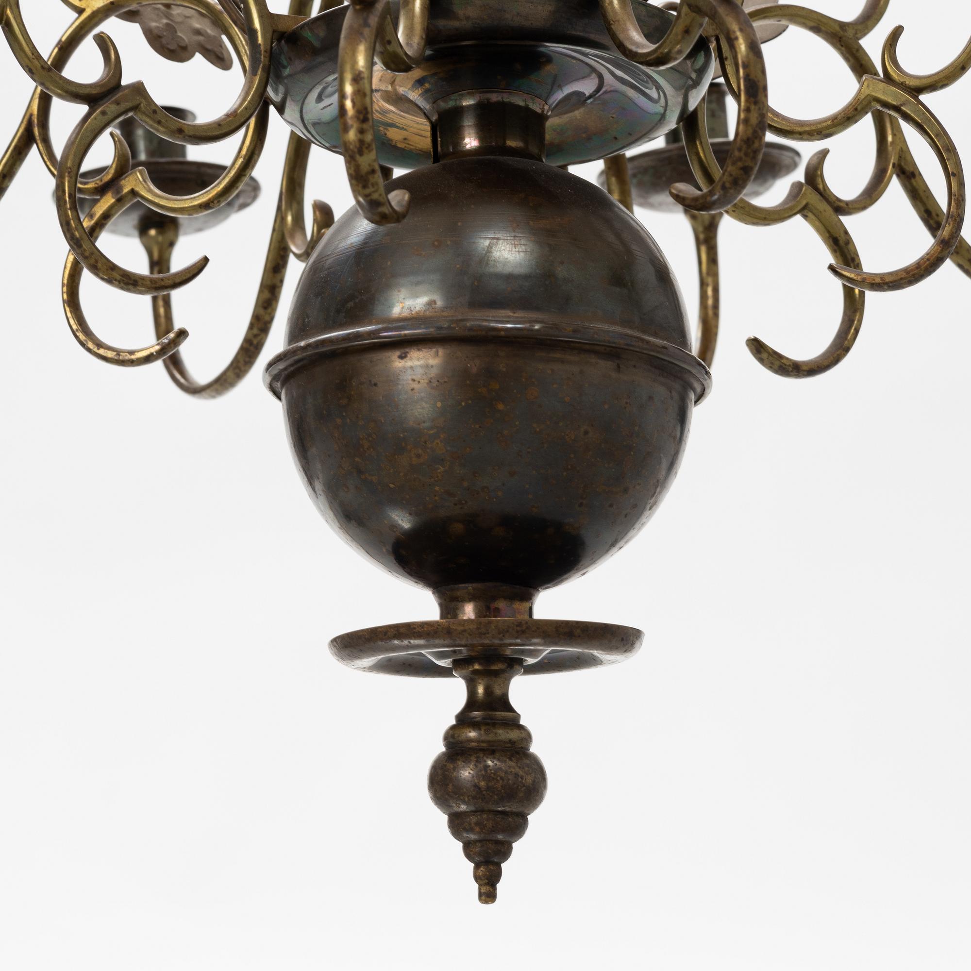 A Baroque style brass chandelier from around the year 1900.