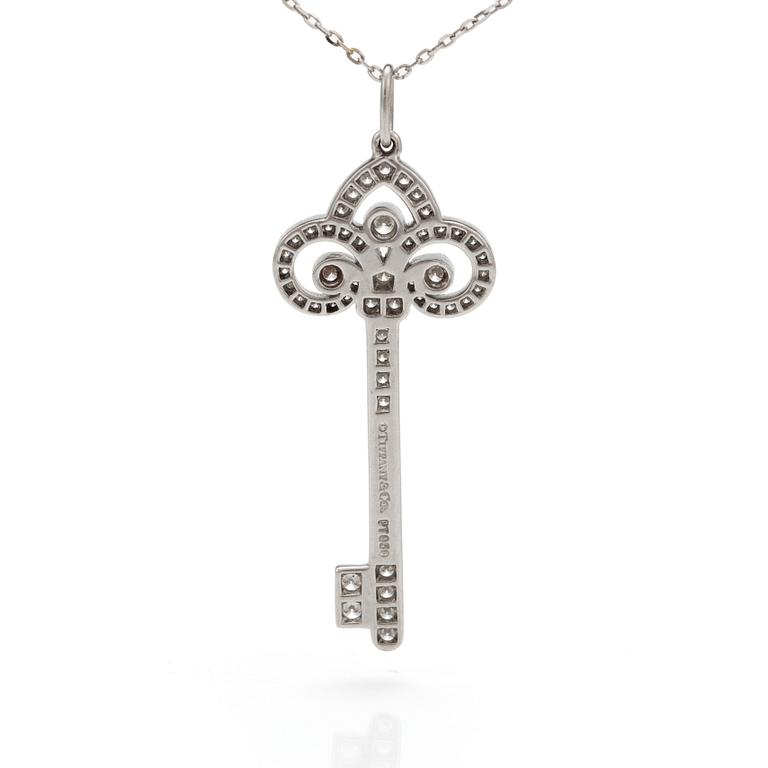 A 'Fleur de lis key' pendant set with round, brilliant-cut diamonds by Tiffany together with a chain.