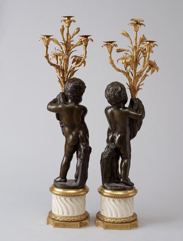 A pair of Louis XVI-style 19th century gilt and patinated bronze marble four-light candelabra.