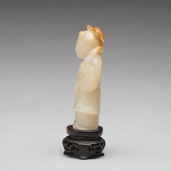 A carved nephrite figure of a boy with a lotus branch, Qing dynasty (1644-1912).