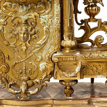 A mantle clock and a pair of candelabra, Louis XVI style, ca 1900.