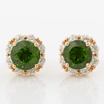 A pair of earrings in 14K gold with green faceted tourmalines and round brilliant-cut diamonds.