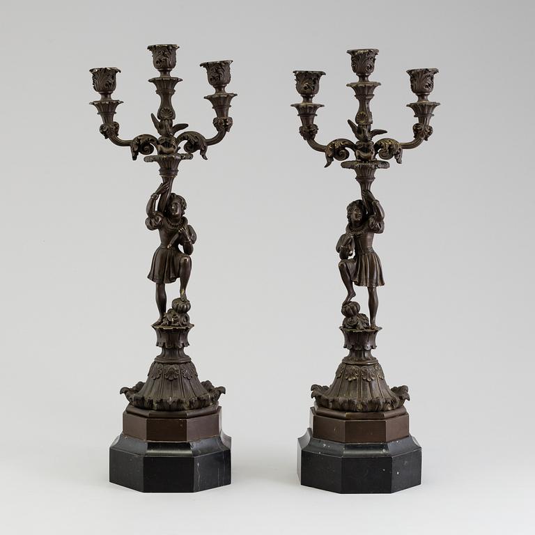 A pair of late 19th century patinated brass candelabra.