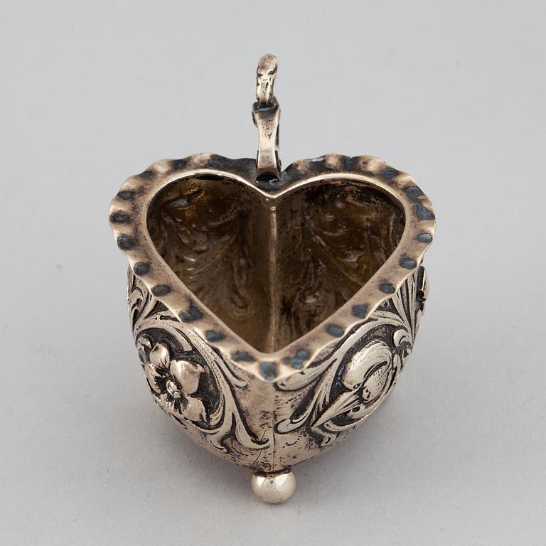 A small silver Baroque style  heart-shaped jug on ball feet.