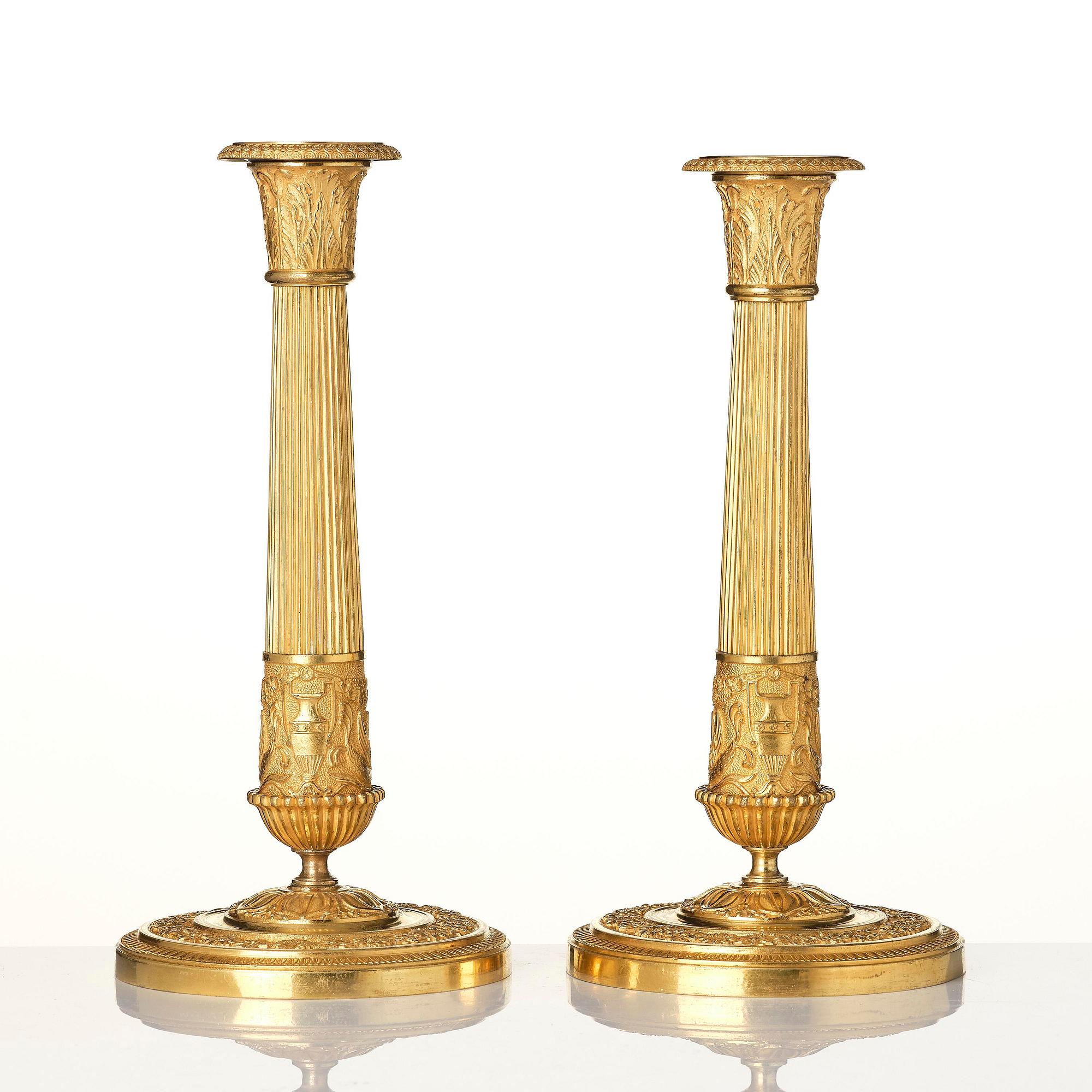 A pair of French Empire ormolu candlesticks, early 19th century.