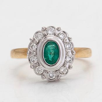 A 14K gold ring, with an oval emerald and diamonds totalling approximately 0.20 ct. Finnish hallmarks.