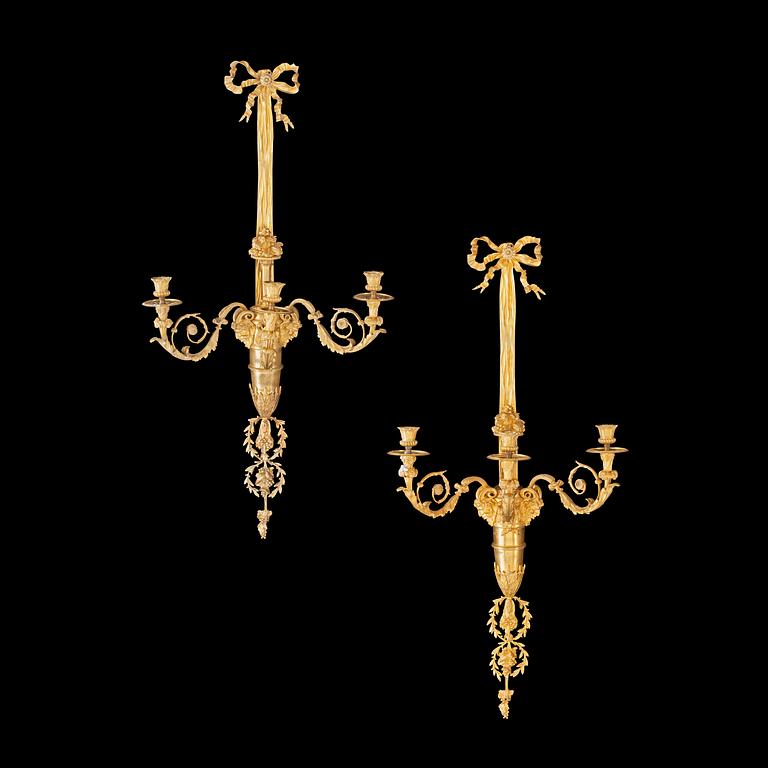 A pair of Louis XVI-style 19th century gilt bronze three-light wall-lights.