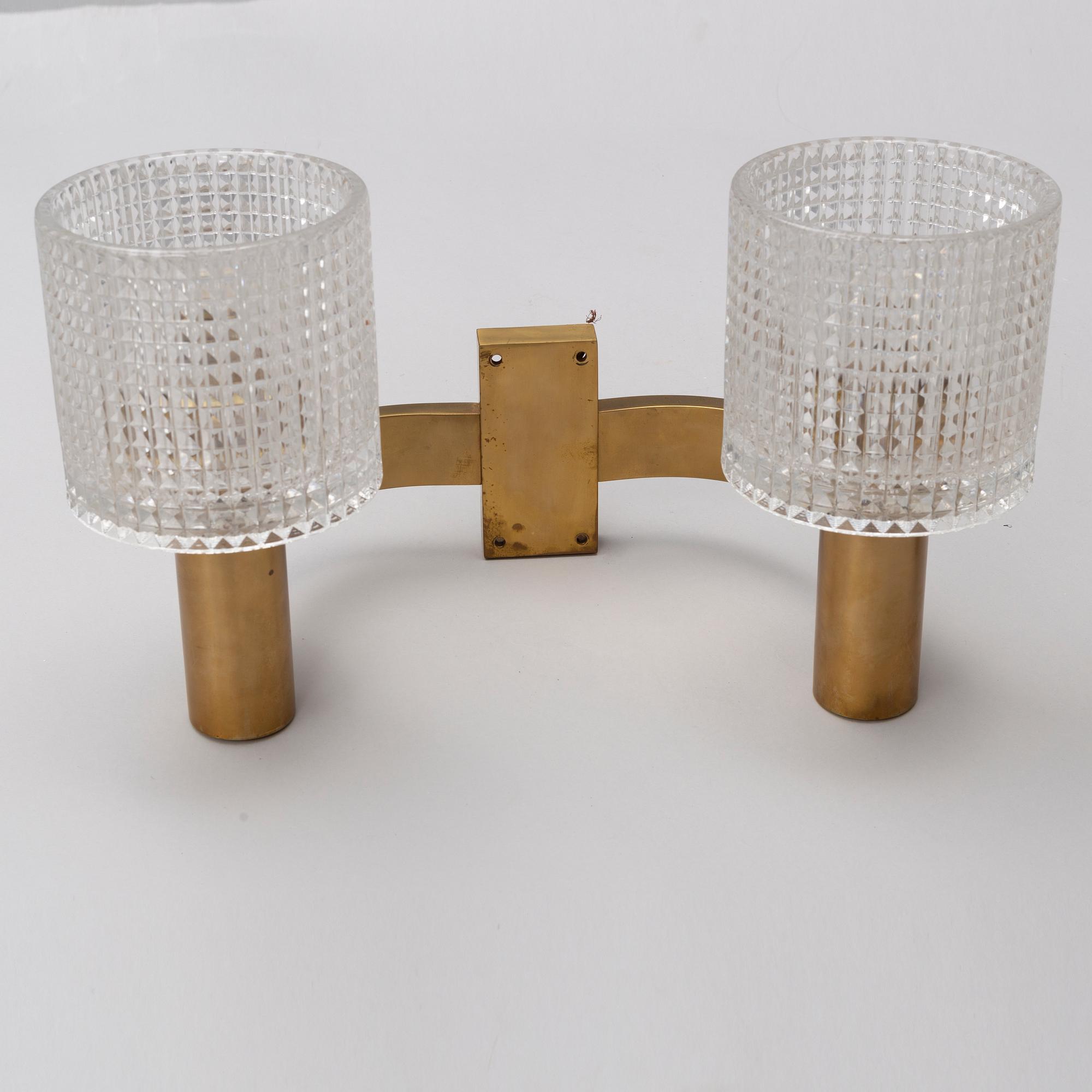 A pair of the 20th century brass and glass wall lights.