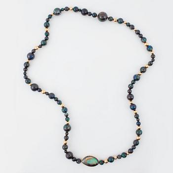 A necklace with beads of boulder opals, Ø 17.3-5.3 mm and gold beads. Made by Gaudi, Stoclkholm 1989.