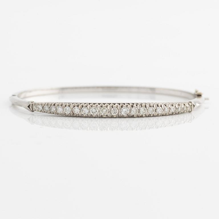 A bangle in 18K gold set with round brilliant-cut diamonds.