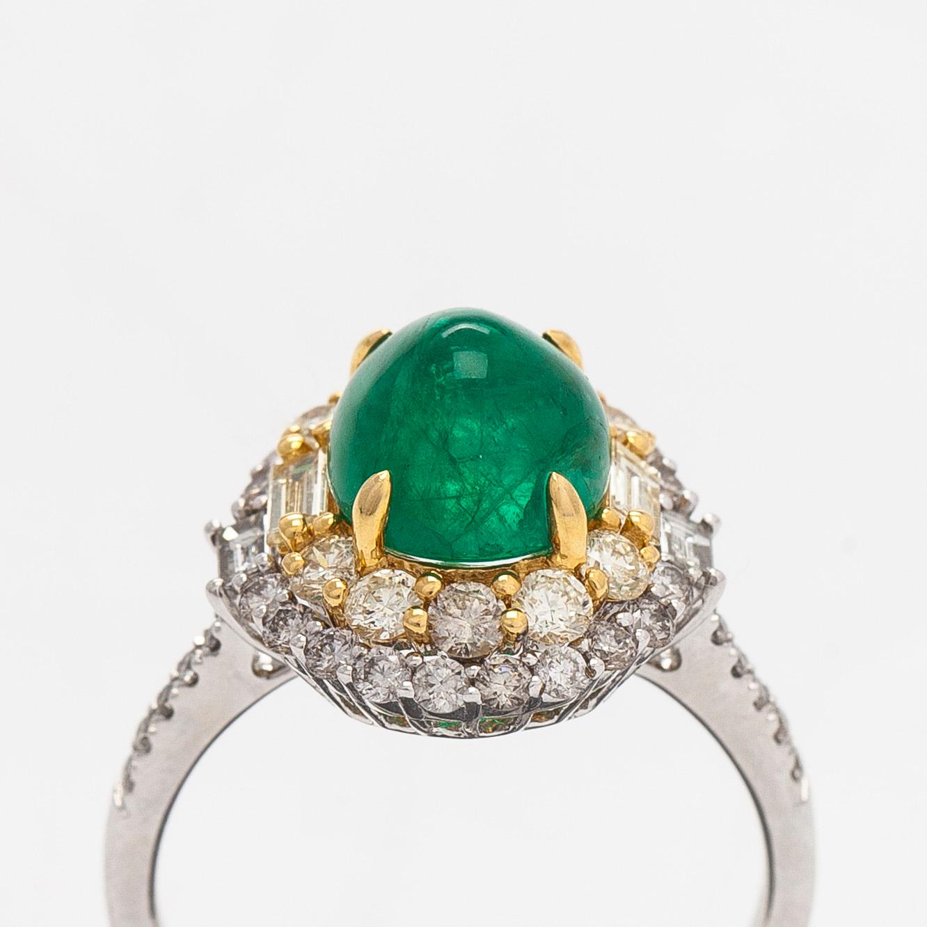 An 18K whitegold ring set with a cabochon-cut emerald and baguette- and brilliant-cut diamonds.