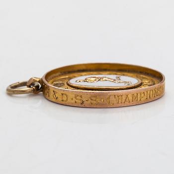 A 9K gold and enamel pendant with football motif. Birmingham, England, 1927.