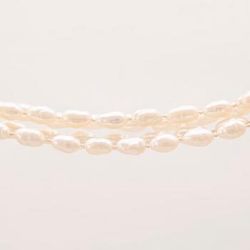 A necklace of cultured pearls set with a 14K gold lock and round brilliant cut diamonds.