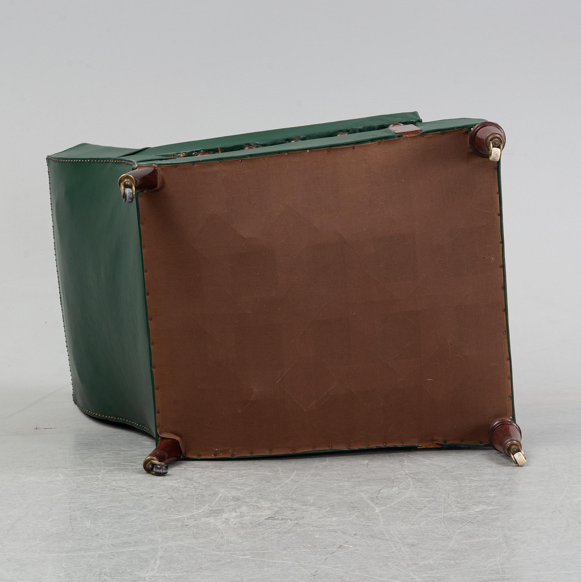 An early 20th Century easy chair with leather upholstery.