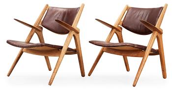 70. A pair of Hans J Wegner oak and brown leather easy chairs, Carl Hansen & Son, Denmark 1950's-60's.