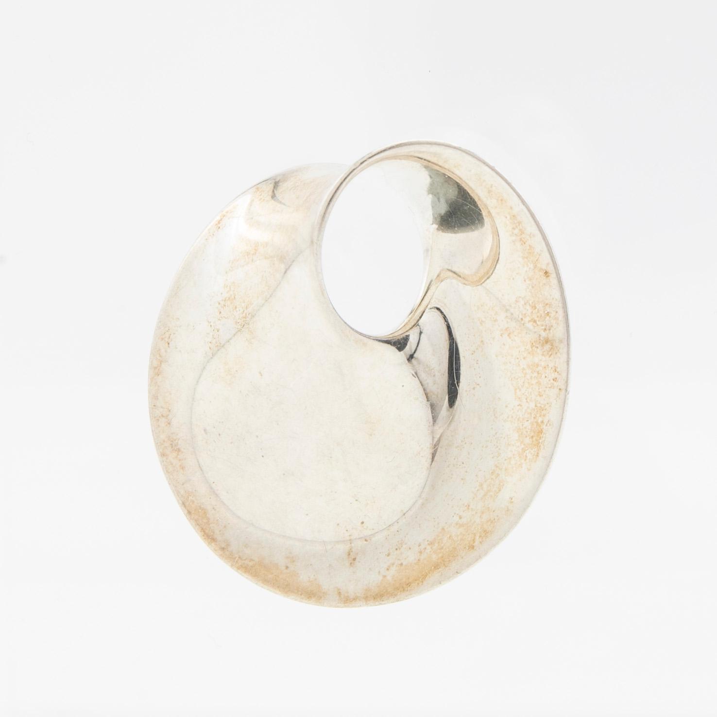 Vivianna Torun Bülow-Hübe, Hängsmycke/brosch, "Möbius", samt gummicollier, för Georg Jensen, Danmark.
