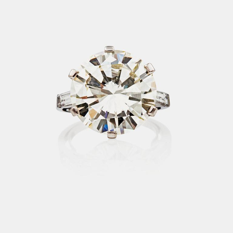 A 8.87 cts brilliant-cut diamond, flanked by two baguette-cut diamonds, ring. Quality circa M-O (Cape)/VVS1.