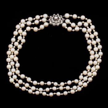 22. A three strand cultured pearl necklace with a clasp decorated with diamands.