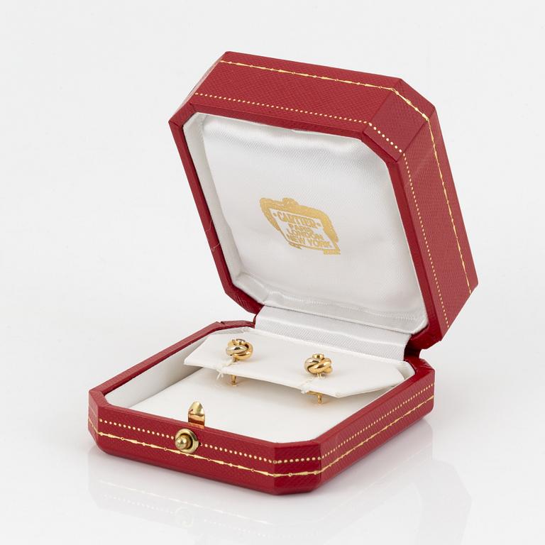 A pair of 18K gold Cartier "Trinity" earrings set with round brilliant-cut diamonds.