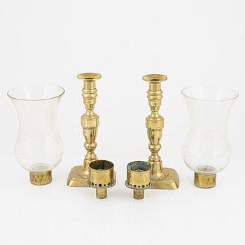 A pair of brass candlesticks with storm glass, 19th century.