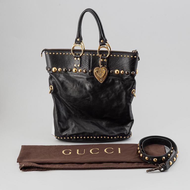 Gucci, a black leather handbag.