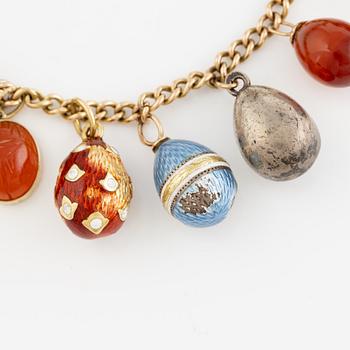 Bracelet with charms in the shape of eggs, the bracelet is 14K gold and 13 loose charms in the shape of eggs.