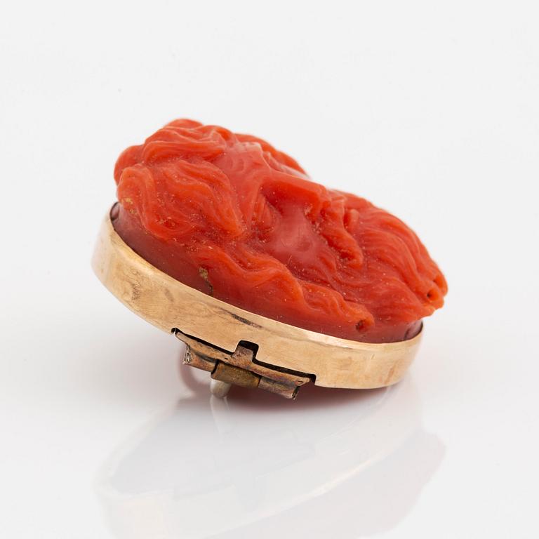 A 14K gold and coral cameo brooch.