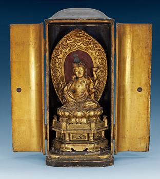 1500. A Japanese gilt lacquer figure of seated Buddha in a wooden shrine, 19th Century.