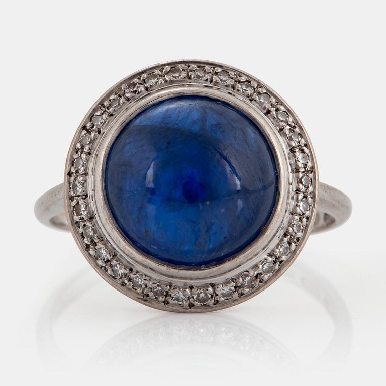 An A Tillander ring in 18K white gold set with a cabochon-cut sapphire and eight-cut diamonds.