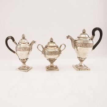 A three pcs Empire silver tea service unknown hallmarks, toal weight 1133 grams.