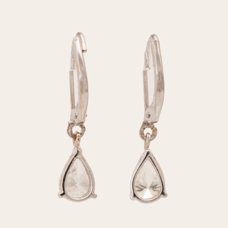 A pair of 18K white gold earrings set with pear cut diamonds.