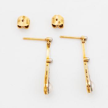 Ett par örhängen med halvpärlor och diamanter.