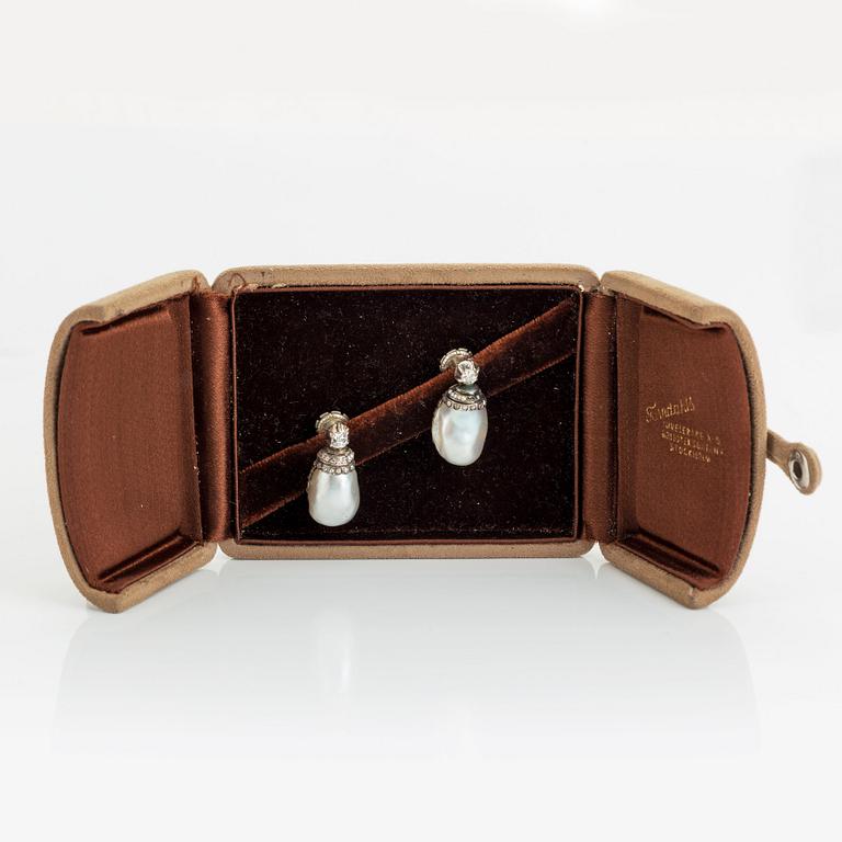 A pair of silver and pearl earrings set with old- and rose-cut diamonds.