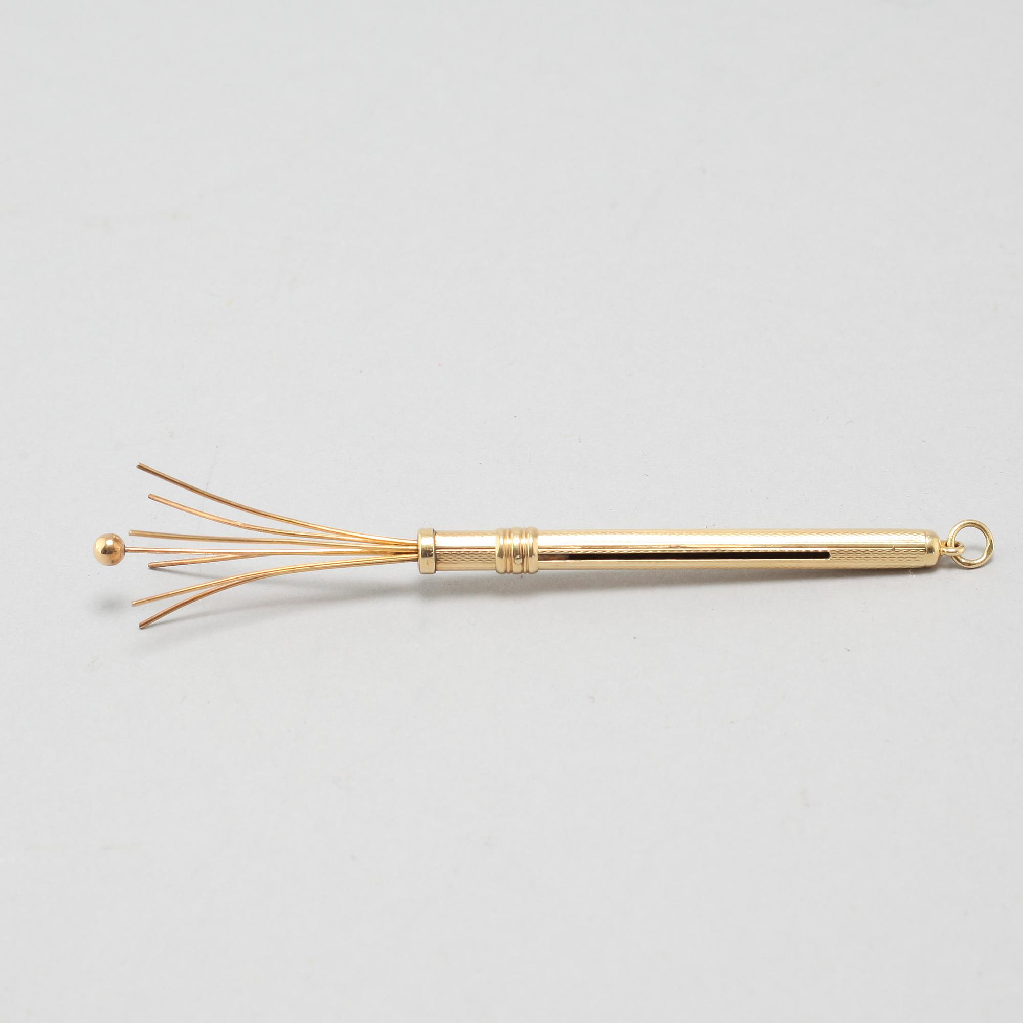 An 18k gold champagne whisk.