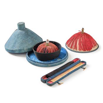 Two boxes with a mandarin's summer hat and black satin autumn hat and feather with six mandarin hat insignias.