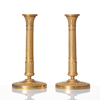 A pair of French Empire ormolu candlesticks, early 19th century.