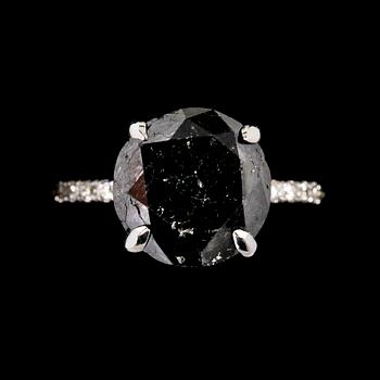 1130. RING, svart briljantslipad diamant, 6.40 ct samt små vita briljantslipade diamanter, tot. 0.40 ct.